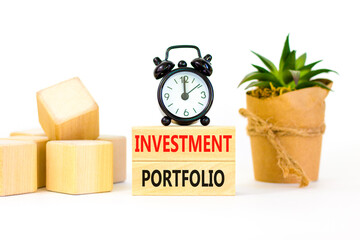 Investment portfolio symbol. Wooden blocks with concept words Investment portfolio on white background. Black alarm clock. Business investment portfolio concept. Copy space.