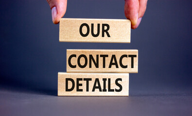 Our contact details symbol. Concept words Our contact details on wooden blocks. Businessman hand. Beautiful grey table grey background. Business our contact details concept. Copy space.