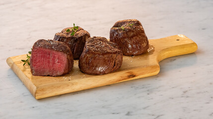 Yummy filet mignon steak on a wooden chopping board