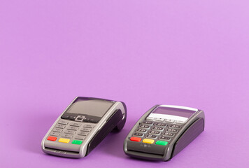 Closeup of two electronic payment terminals isolated on light purple background