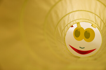 Yellow play tunnel with a smiley face
