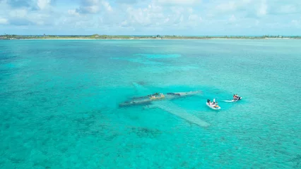 Foto op Plexiglas Aerial view of people  in a white tiny boat at Exumas, Bahamas © Dronevideosdallas/Wirestock Creators