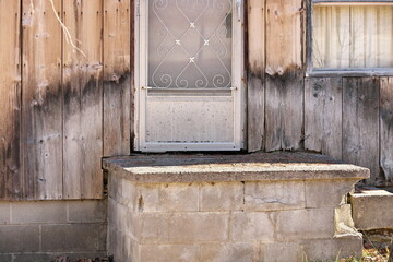 Close up of Weathered Wood Siding Beginning to Rot Around Front Step of Cottage or House