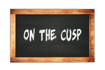 ON  THE  CUSP text written on wooden frame school blackboard.