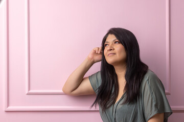 portrait of a mexican empowered woman isolated on pink background