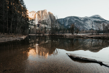Merced River surrounded by mountains in Yosemite National Park at sunrise, United States