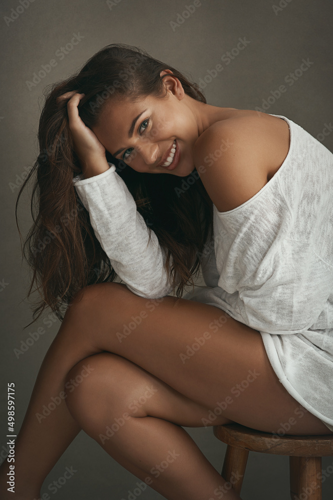 Sticker Life isnt perfect, but your hair can be. Portrait of a beautiful young woman sitting on a stool against a brown background in studio.