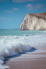 Waves on the sunny sand beach, Jurassic Coast, Dorset, UK