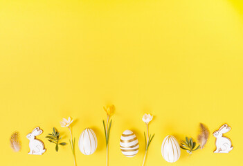 Festive Easter border, frame from easter eggs and spring flower crocus on yellow background....