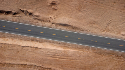 Aerial top view of a road through a dry desert