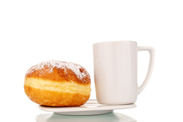 One sweet donut with jam filling with a white ceramic cup on a saucer, close-up, isolated on a white background.