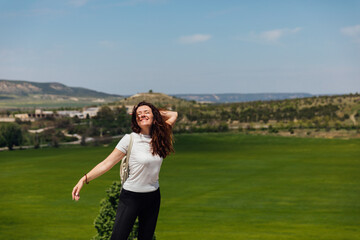 woman traveler climbs to the top of a mountain nature