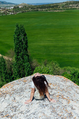 woman traveler climbs to the top of a mountain nature