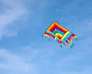 colorful vividly colored kite that I fly in the sky symbol of parental management that should hold a string and let it go a little every now and then to give freedom