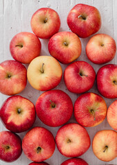 Fresh red apples on a white wooden table. Top view.