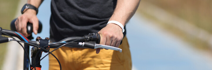 Man with mountain bike standing on bicycle path closeup