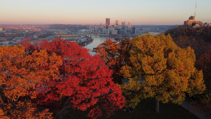 Beautiful view of a cityscape surrounded by colorful autumn trees in Pittsburgh, Pennsylvania - obrazy, fototapety, plakaty