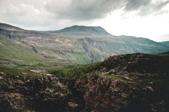 Beautiful landacape view of large green rocky hills against light cloudy sky