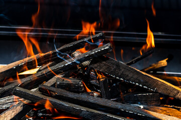 Grill pit with glowing and flaming hot open fire with red flame