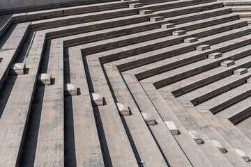 Concrete bleachers in a sunny outdoor amphitheater.