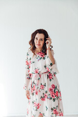 beautiful brunette woman in a summer dress with flowers