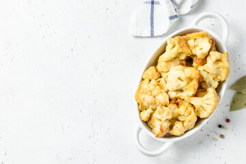 Crispy BBQ beer battered cauliflower nuggets  in baking dish. Space for text.