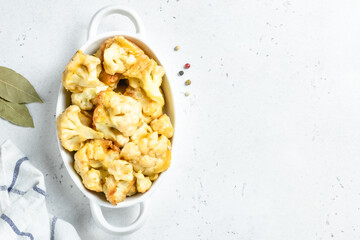 Vegan fried cauliflower nuggets  in baking dish. Space for text.