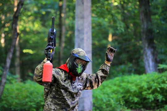 Paintball player surrenders with raised hands