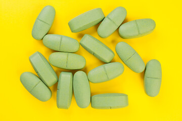 Green cold pills on a yellow