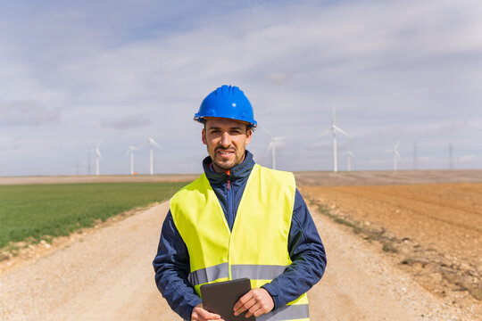 Portrait of a young adult male worker at a renewable energy plant. Image of a company that generates electricity through wind turbines.