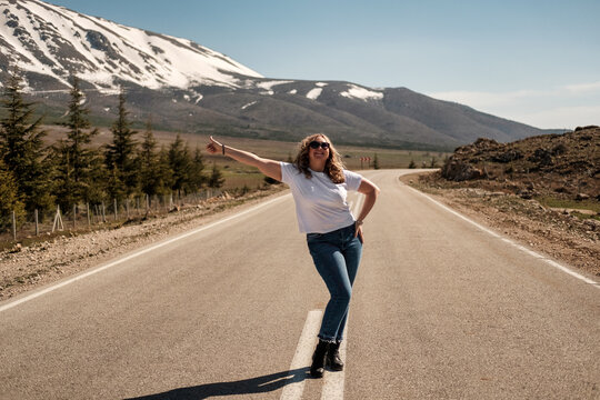 Woman hitchhiking on a mountain road