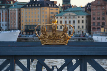 Gold crown on a bridge grille in Stockholm on a sunset light