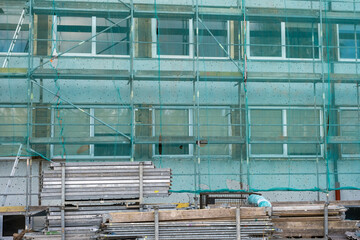 Building under construction wrapped green protection safety net