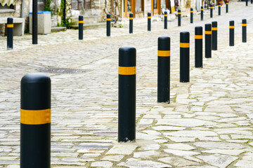 black and yellow colored columns for protection the sidewalk from the road