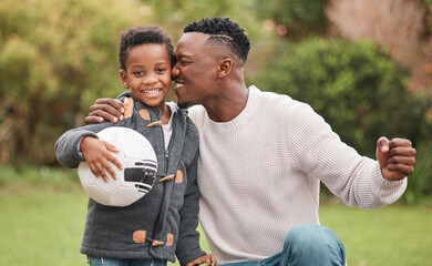 Hes going to become a pro. Portrait of a little boy and his father playing with a soccer ball together outdoors.