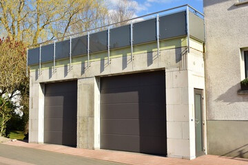 Moderne Beton-Garage mit Automatik-Tor in der Hauszufahrt