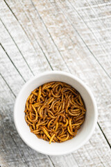 Fried salty worms. Roasted mealworms in bowl.
