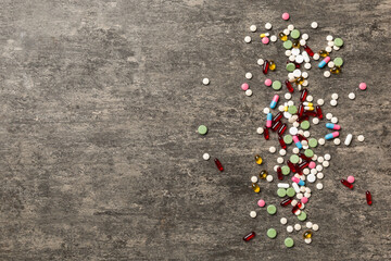 assorted pills and tablets top border over colored background. Many different pills and space for text on colorful background, top view