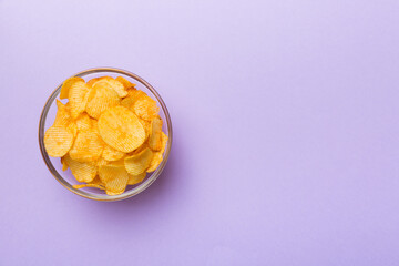 Potato chips on bowl isolated on colored background. Delicious crispy potato chips in bowl. Space for text. Top view