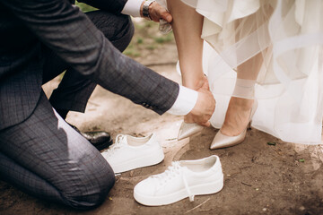 groom fastening bride's shoes