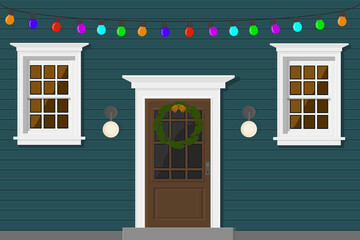 blue house with a door and windows in the evening with a garland for the holiday