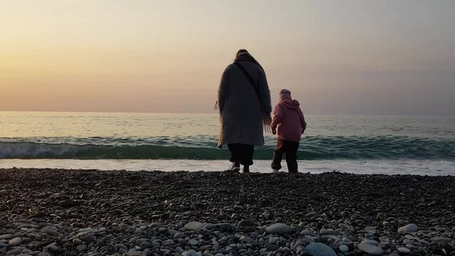 Mother and children playing on coast sea evening. sunset and happy people.
