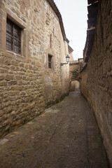 Fototapeta na wymiar A narrow street in a medieval district of the city with a cobbled stone street. Úbeda, Spain.