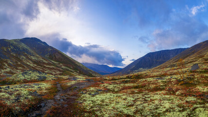 Autumn colorful tundra on the background mountain peaks. Mountain landscape in Kola Peninsula, Arctic, Khibiny Mountains.