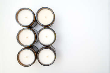 Top view of six candles in a line on a white countertop