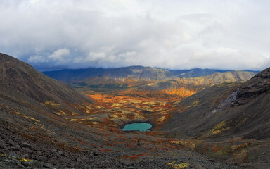 Lake with turquoise water in the mountains in autumn on a cloudy day. view from above