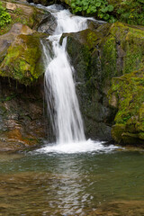 Fototapeta na wymiar Small mountain waterfalls in forest
