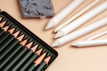 Drawing tools. Pencils in a metal box, an eraser and a set of white feathers