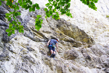 Fototapeta premium Man climbing on a big limestone wall