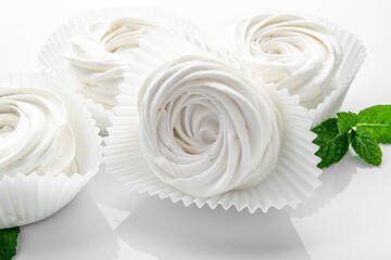 Small white meringues on a white background.